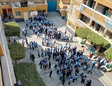 Blick von oben in den Schulinnenhof einer ägyptischen Schule. Die Schüler*innen haben Pause und sind im Hof versammelt.