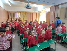 Blick in ein Klassenzimmer des Kindergartens in Ägypten. Die Kinder tragen rote Pullover und sitzen an grünen Pulten.