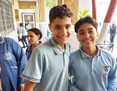 Zwei ägyptische Schüler in blauer Schuluniform lächeln in die Kamera.